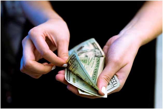 A woman counting dollar bills for everyday expense